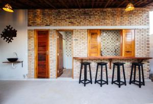 a bar with stools in front of a brick wall at Casamarias duplo in Barra Grande +15 photos