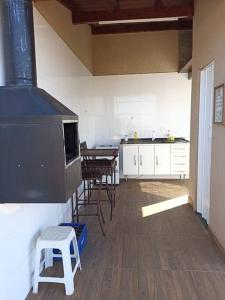 a kitchen with a stove and a table and chairs at Lindo Loft no centro de Assis in Assis +9 photos