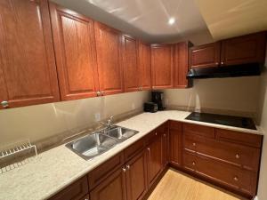 a kitchen with wooden cabinets and a sink at Luxury Apartment Living in Mississauga