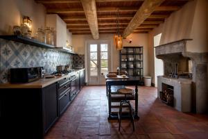 a large kitchen with a table and a stove at Villa La Salina in Bibbona