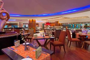 a restaurant with tables and chairs and a bar at The Westin Dhaka in Dhaka
