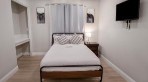 a small bedroom with a bed and a flat screen tv at Xlnc Exotic Home Lemon Groove in Lemon Grove
