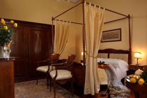 a bedroom with a canopy bed and a table and chairs at Pensione Accademia - Villa Maravege in Venice