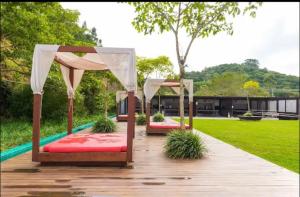 a row of beds on a wooden deck in a park at Apartamento praia brava in Itajaí