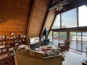 a living room with a couch and a tv at Chalet on Private Alderbrook Lake in Bolton