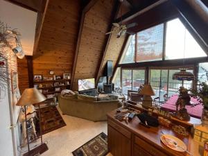 a living room with a couch and a large window at Chalet on Private Alderbrook Lake in Bolton