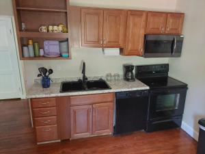 a kitchen with wooden cabinets and a sink and a stove at 5BR Home Pool, hot tub, pet friendly by ARK Experience in Williamstown