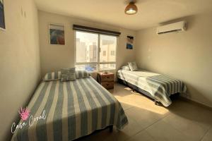 une chambre avec deux lits et une fenêtre dans l'établissement Depa Coral con Club de Playa Exclusivo Playa Bonfil Diamante, à Acapulco 29 autres photos