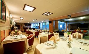 a restaurant with tables and chairs with white tablecloths at Xima Central Tacna in Tacna