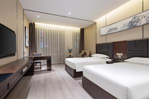 A bed or beds in a room at 宜昌虹桥国际大酒店