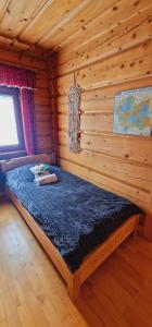 sypialnia z łóżkiem w chacie z bali w obiekcie Góralska Chata & Spa w Muszynie