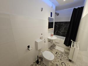 un bagno bianco con un water e un lavandino di Zentral Duisburg 2 a Duisburg