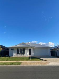 a white house with a porch on a street at Brand new 4 bedroom home with Golf Views in Yarrawonga