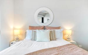a bedroom with a large white bed with a mirror at By The Beach - Clubb Coolum Beachside Resort in Coolum Beach +21 photos