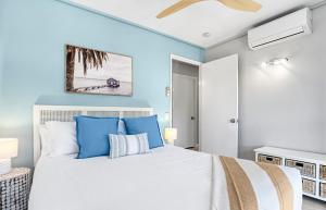 a bedroom with a white bed with blue walls at By The Beach - Clubb Coolum Beachside Resort in Coolum Beach
