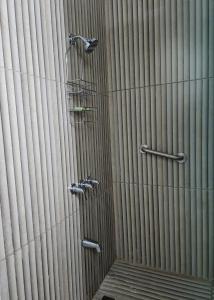 a shower with two faucets on a wall at Sky Beach Hotel in Hopewell +34 photos