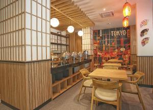 a restaurant with tables and chairs in a room at Mimaru Hotel Jakarta in Jakarta