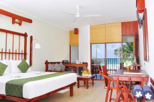 een slaapkamer met een bed, een tafel en een bureau bij Koggala Beach Hotel in Koggala