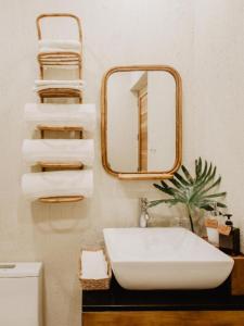 a bathroom with a sink and a mirror at Frangipani El Nido in El Nido