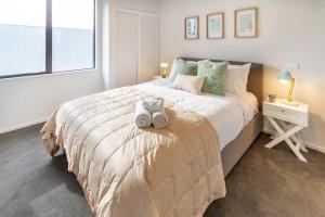 a bedroom with a bed with two stuffed animals on it at Stadium Walk Apartment - City Centre and Parking in Christchurch