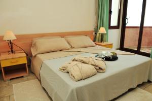 a bedroom with a bed with towels on it at Hotel Castello Budoni in Budoni