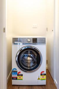 a washer and dryer sitting inside of a room at Stadium Walk Apartment - City Centre and Parking in Christchurch