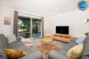 Callala BayNautilus Pet Friendly 5 Mins Walk to Bay的配有沙发和平板电视的客厅