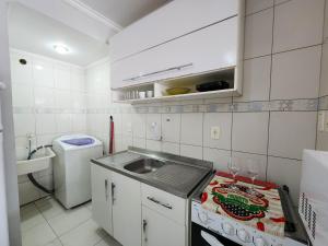 a small kitchen with a sink and a counter top at Apto El Shadday 202 cento e cinqüenta metros do Mar in Bombinhas
