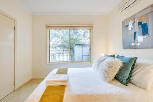 a bedroom with a large white bed with a window at Glen Waverley 3BRM Vacation Home FreeParking Netflix in Glen Waverley