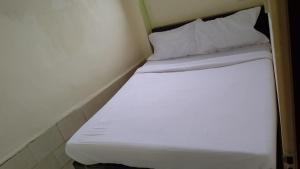 a white bed with two pillows in a room at Hotel Urban Comfort in Mumbai