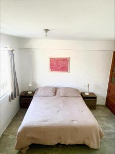 a bedroom with a bed with two nightstands and two lamps at Casa Danda Punta Hermosa in Punta Hermosa