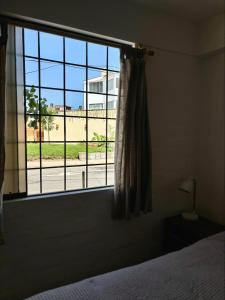 a bedroom with a window with a view of a street at Casa Danda Punta Hermosa in Punta Hermosa