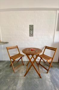 a wooden table and two chairs next to a brick wall at Casa Danda Punta Hermosa in Punta Hermosa