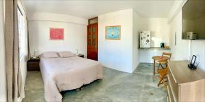 a bedroom with a bed and a table and a kitchen at Casa Danda Punta Hermosa in Punta Hermosa