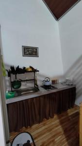 a kitchen with a table with a counter top at Dieng Kilea Homestay in Dieng