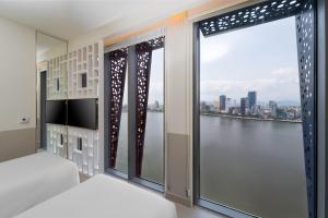 Uma cama ou camas num quarto em Wink Icon Hotel Danang Riverside - Luxury Suites - 24hrs Stay & Rooftop Pool Bar