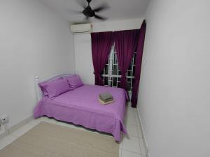 a bedroom with a purple bed with a window at Zanayra Homestay in Melaka +7 photos