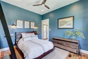 a blue bedroom with a bed and a ceiling fan at The Shotgun House from Fixer Upper - 800 5-Stars - Steps to Silos, BU, & Downtown in Waco