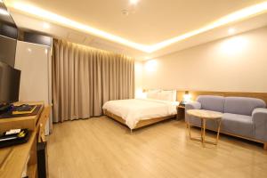 釜山Hotel Prima Busan的配有床和沙发的酒店房间 更多37张照片