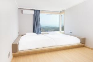 Postel nebo postele na pokoji v ubytování Gyeongju Mauna Ocean Resort