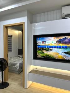 a living room with a flat screen tv on a wall at July homestay huế in Thôn Trường Giang