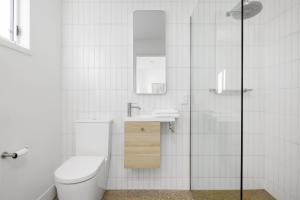 a white bathroom with a toilet and a sink at The Village Belle - Stay In The Heart of Sorrento in Sorrento +17 photos