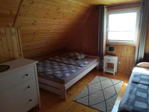 a bedroom with a bed in a wooden cabin at Domki Mantras in Swarzewo
