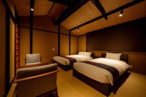 a room with two beds and a chair in it at RESI STAY Palace Gate in Kyoto