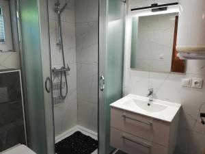 a bathroom with a shower and a sink at Domki Mantras in Swarzewo +56 photos