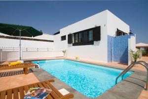 a villa with a swimming pool and a house at Grand Villa Famara Los Mojones by Dolores in Puerto del Carmen