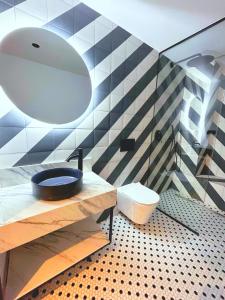 a bathroom with a toilet and a large mirror at Lemon Suites Santander in Santander