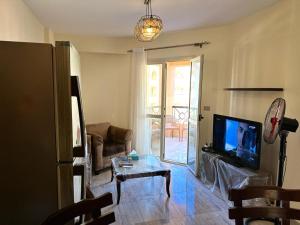a living room with a couch and a tv and a table at غرفة سنجل سي فيو in Sharm El Sheikh