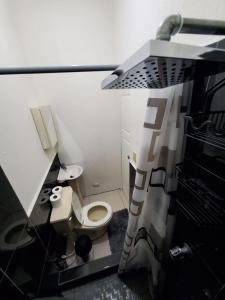 Baño en miniatura con aseo y lavabo en Kokys Guest House, en Nueva San Salvador