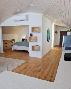 a bedroom with a bed and a wooden floor at The Boatshed, Luxury Waterfront Accommodation in Raglan